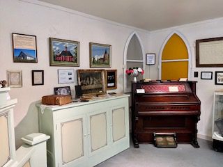 A room with many pictures and a piano