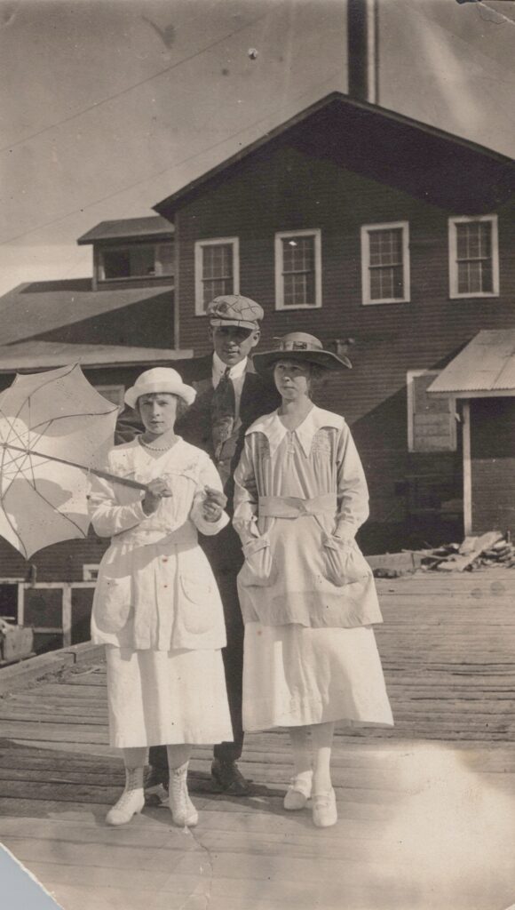A man and two women standing in front of a building.